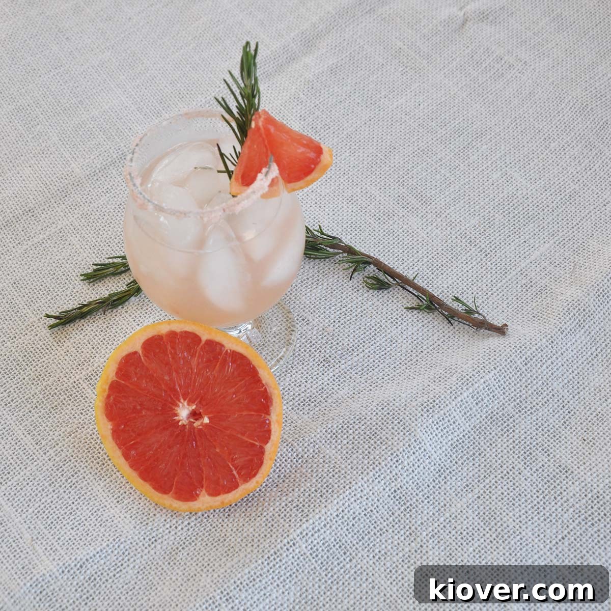 An overhead shot of a Rosemary Infused Salty Dog cocktail, showcasing its vibrant color, salt rim, and elegant rosemary garnish.