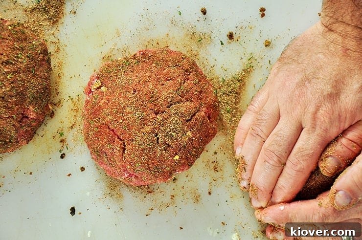 Adding Black rub onto hamburger patties.