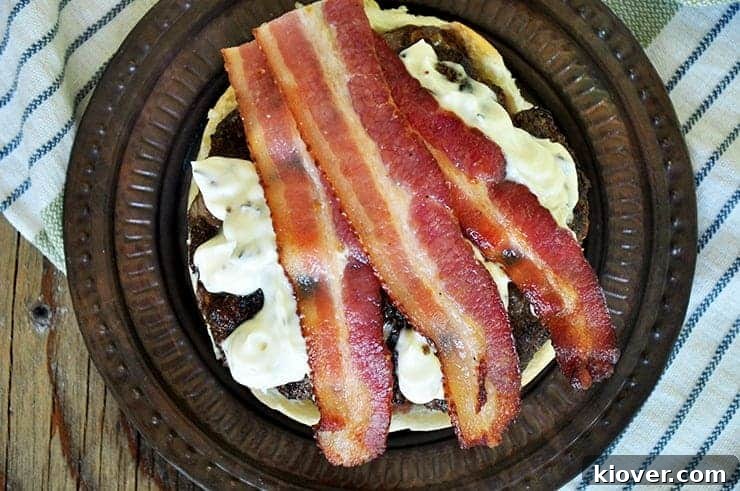 Open faced Black and Blue burger with bacon on top.