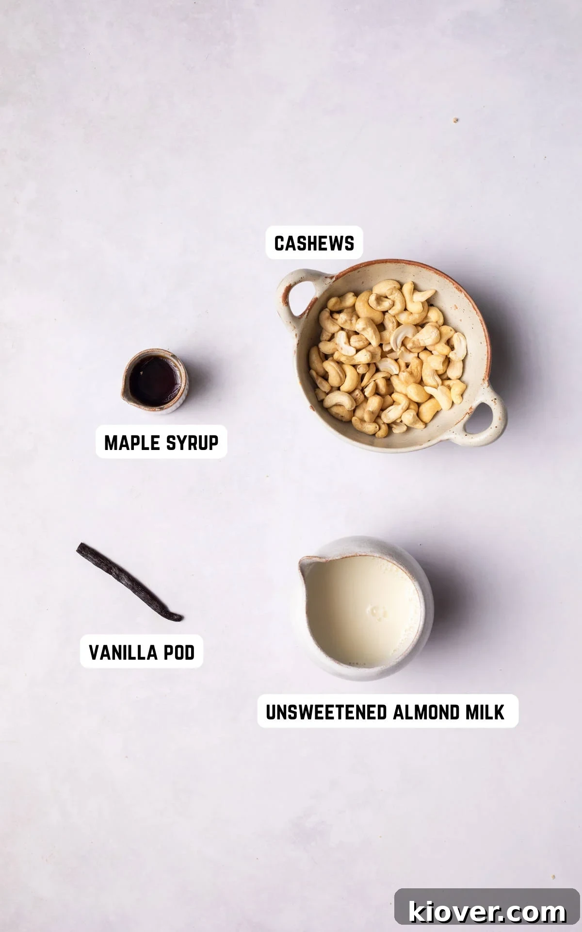 Velvety Cashew Cream 3 Ingredients laid out to make Cashew Cream, including cashews, almond milk, vanilla pod, and maple syrup.