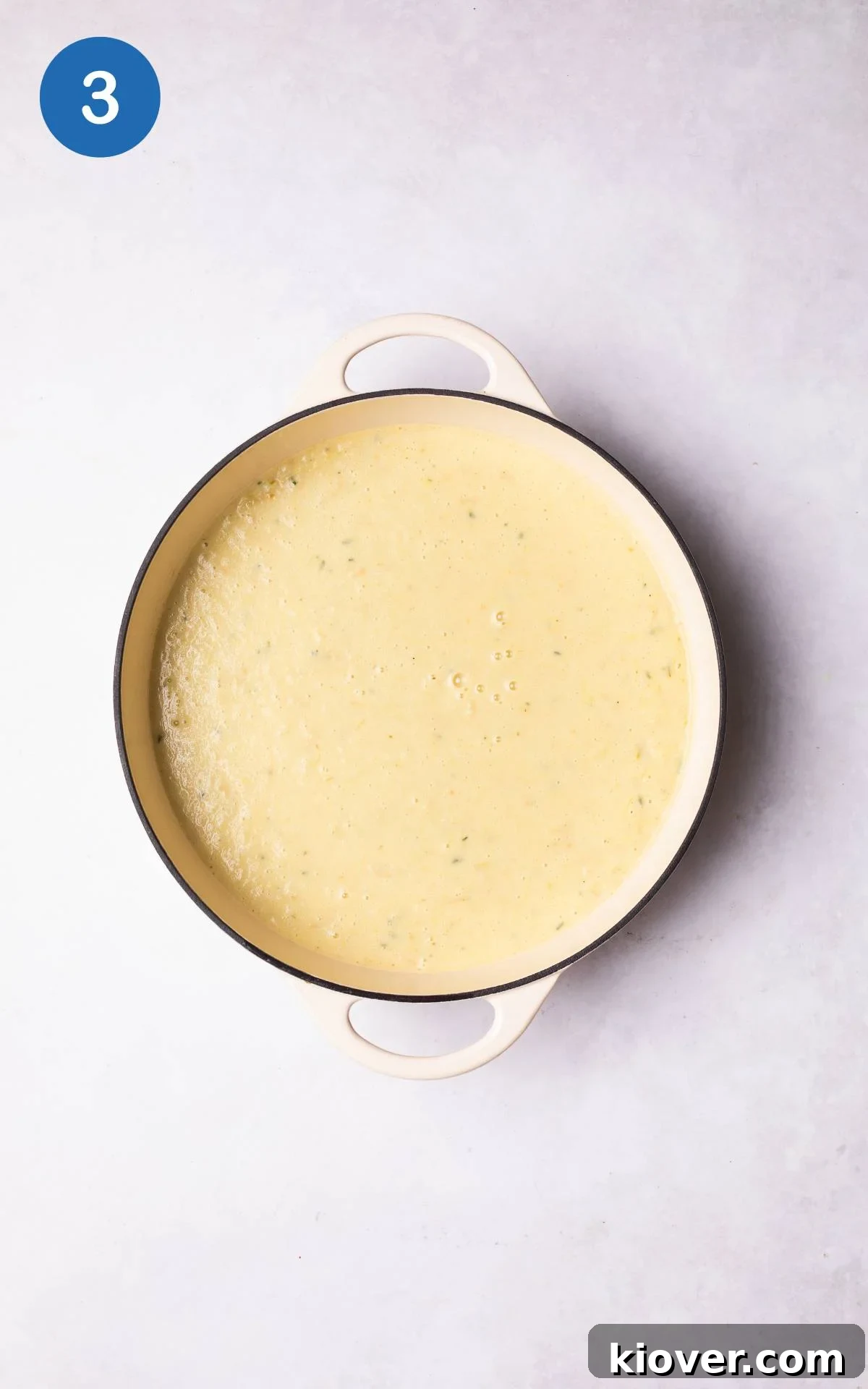 Smooth parsnip soup gently simmering in a large pot on the stove.