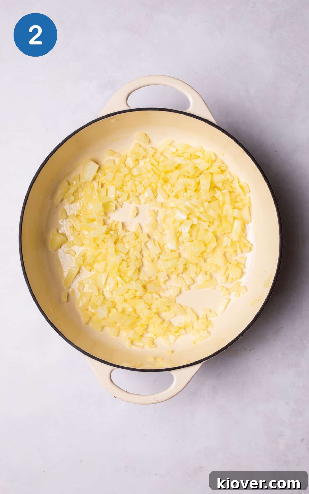 Diced white onion and crushed garlic sizzling gently in a pan with a pool of shimmering extra-virgin olive oil over medium heat.