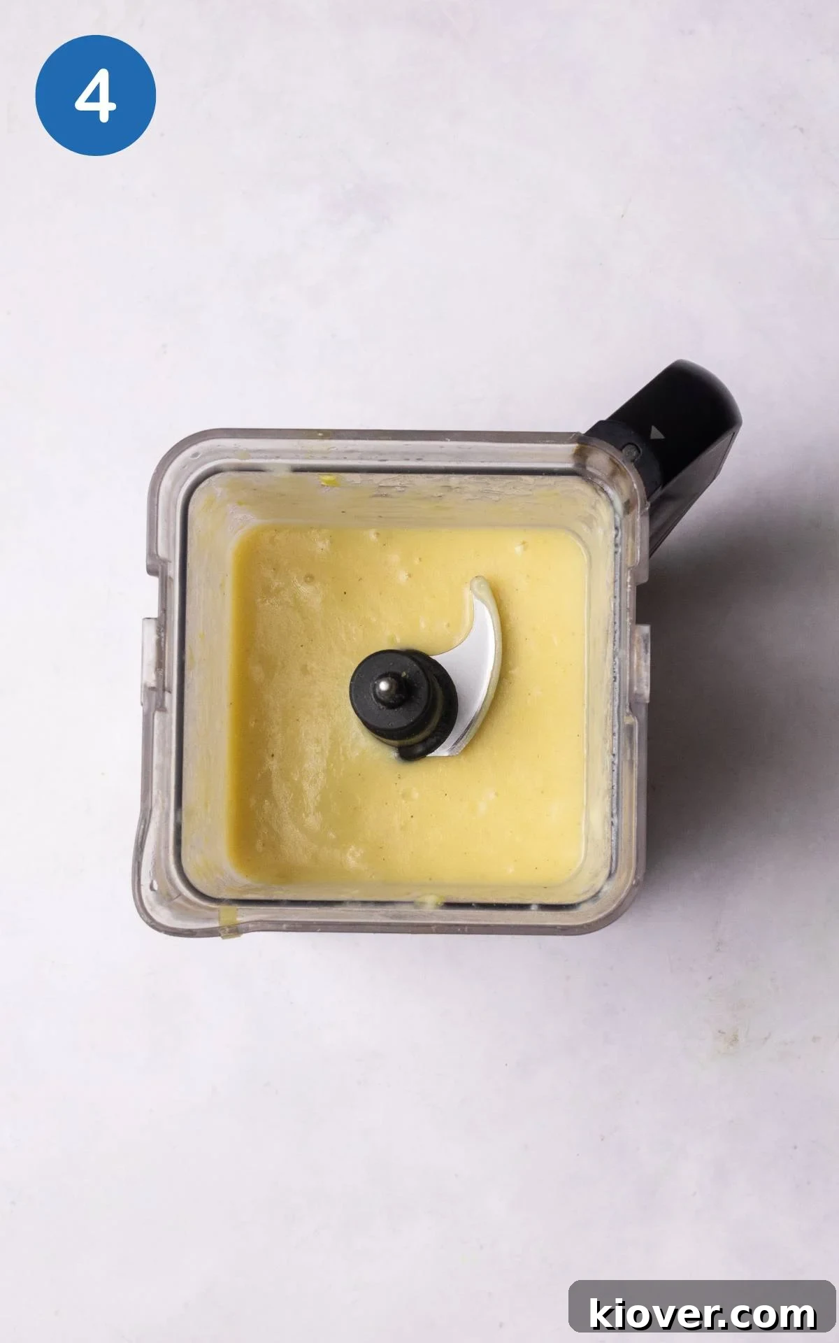 Soup ingredients being blended in an upright blender with vegan yoghurt.