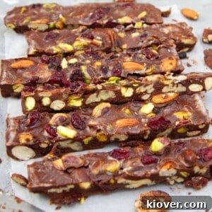 Slices of rich vegan rocky road arranged on parchment paper.