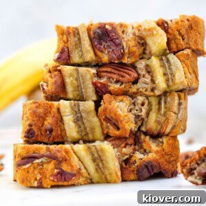 slices of banana bread on top of beach other on white surface with white background.