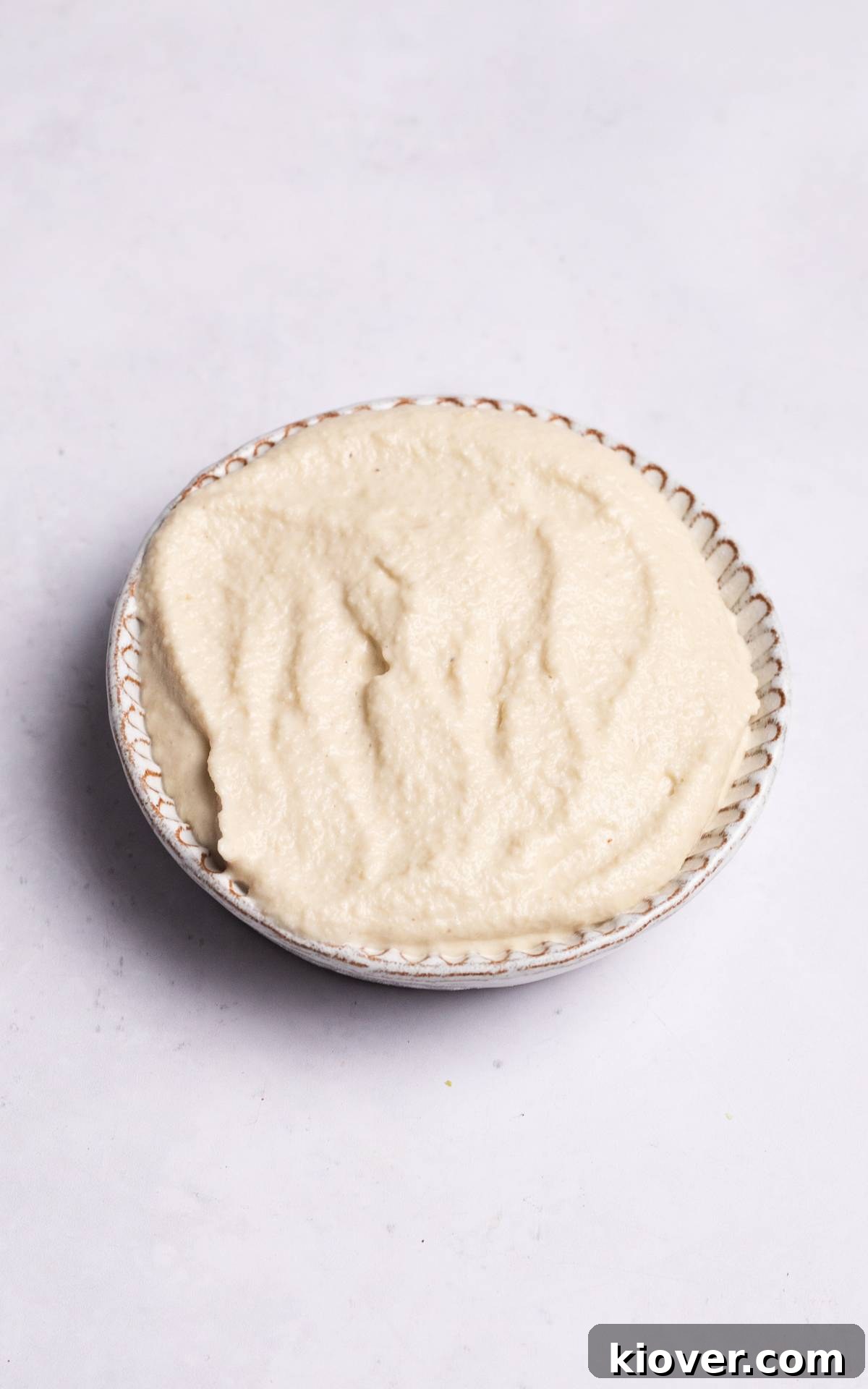 Creamy Vegan Sour Cream 6 A bowl of creamy vegan sour cream substitute, garnished lightly, showcasing its smooth texture.