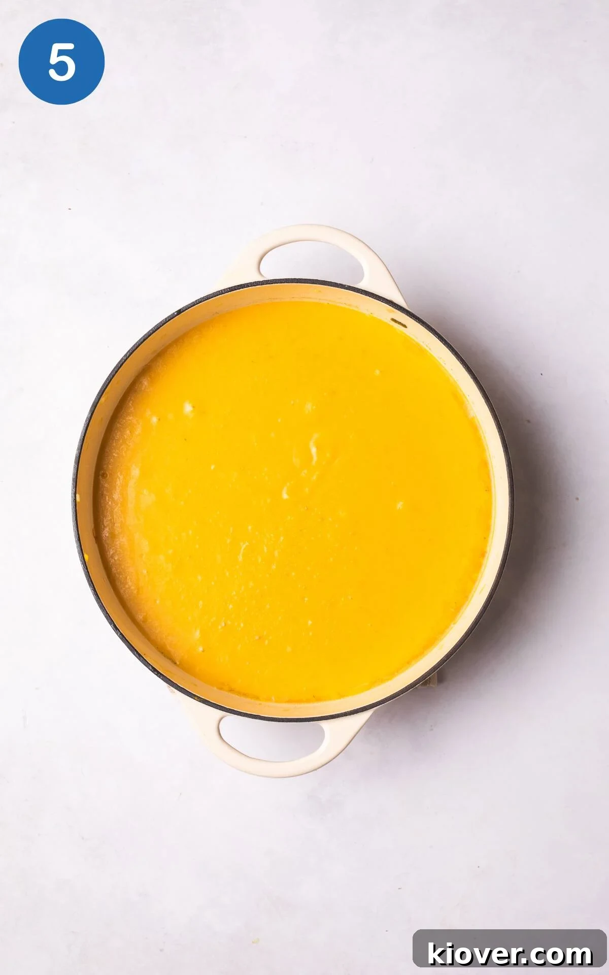 Autumn Squash Comfort 8 Creamy butternut squash soup heating in a pot on the stove, garnished with fresh sage, pumpkin seeds, and chili flakes.