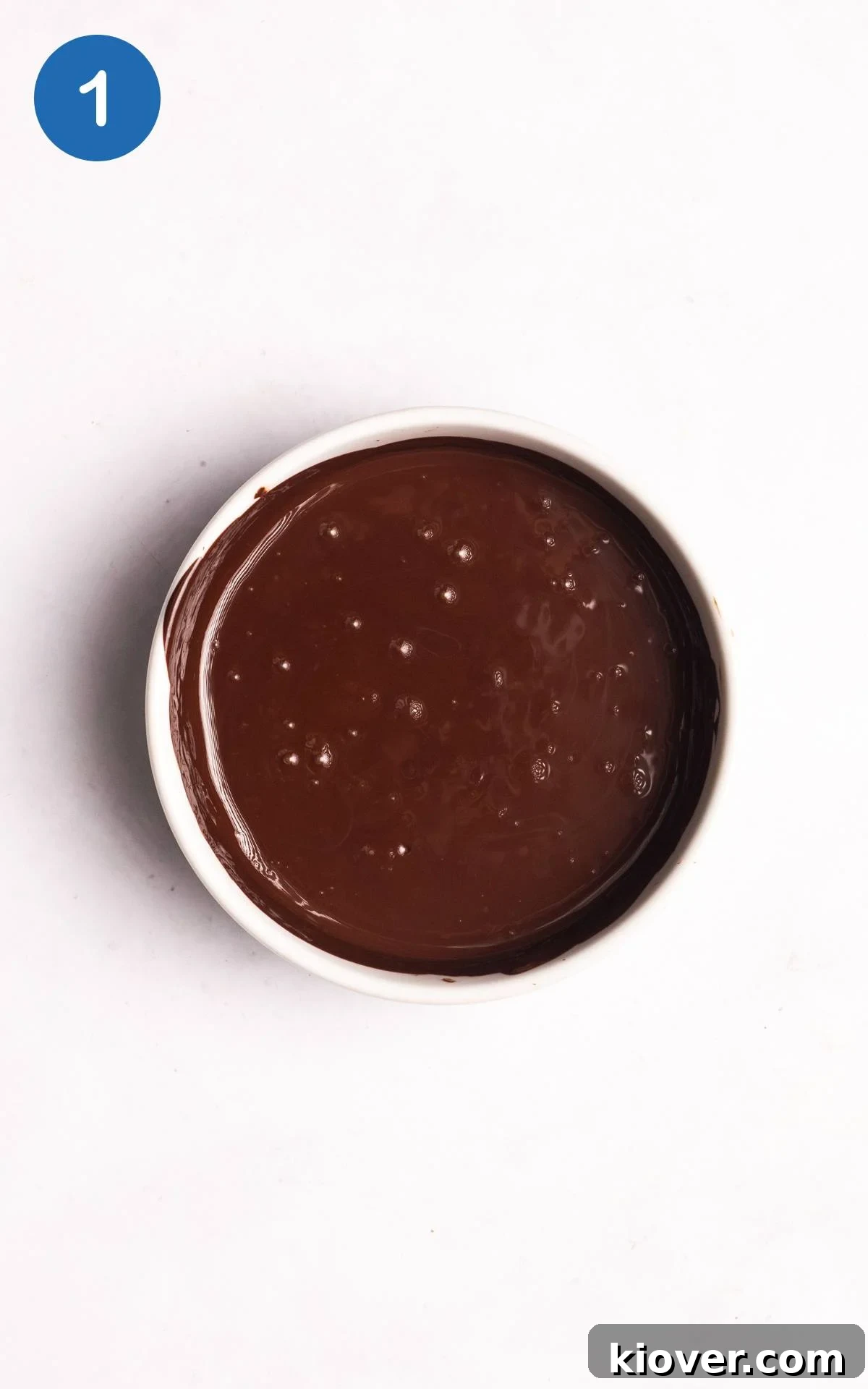 Melted dark chocolate in a heatproof bowl, ready to be mixed with other ingredients for vegan mousse.