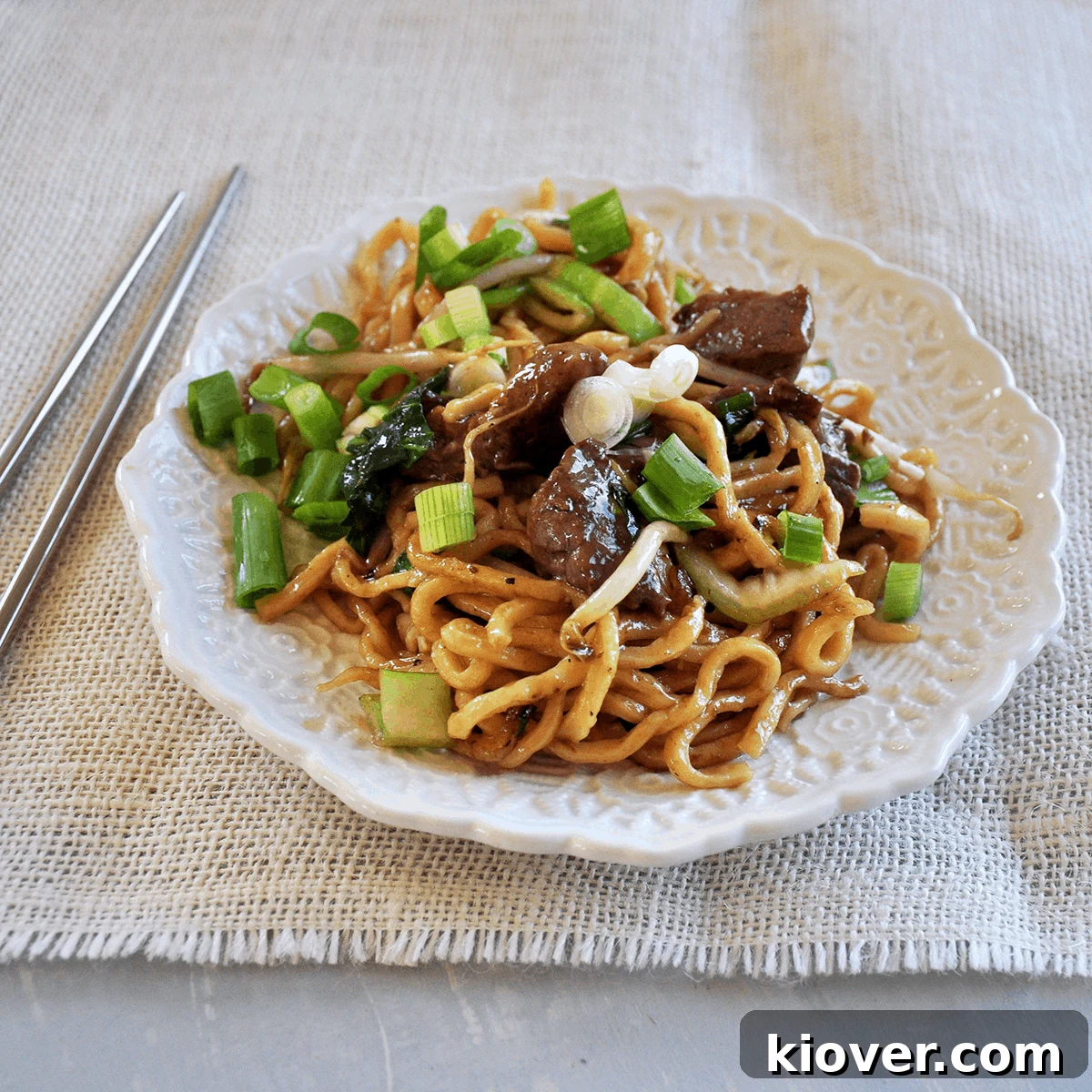 Savory Beef Chow Mein with Noodles Delicious Beef Chow Mein from the side with chopsticks, ready to be enjoyed.