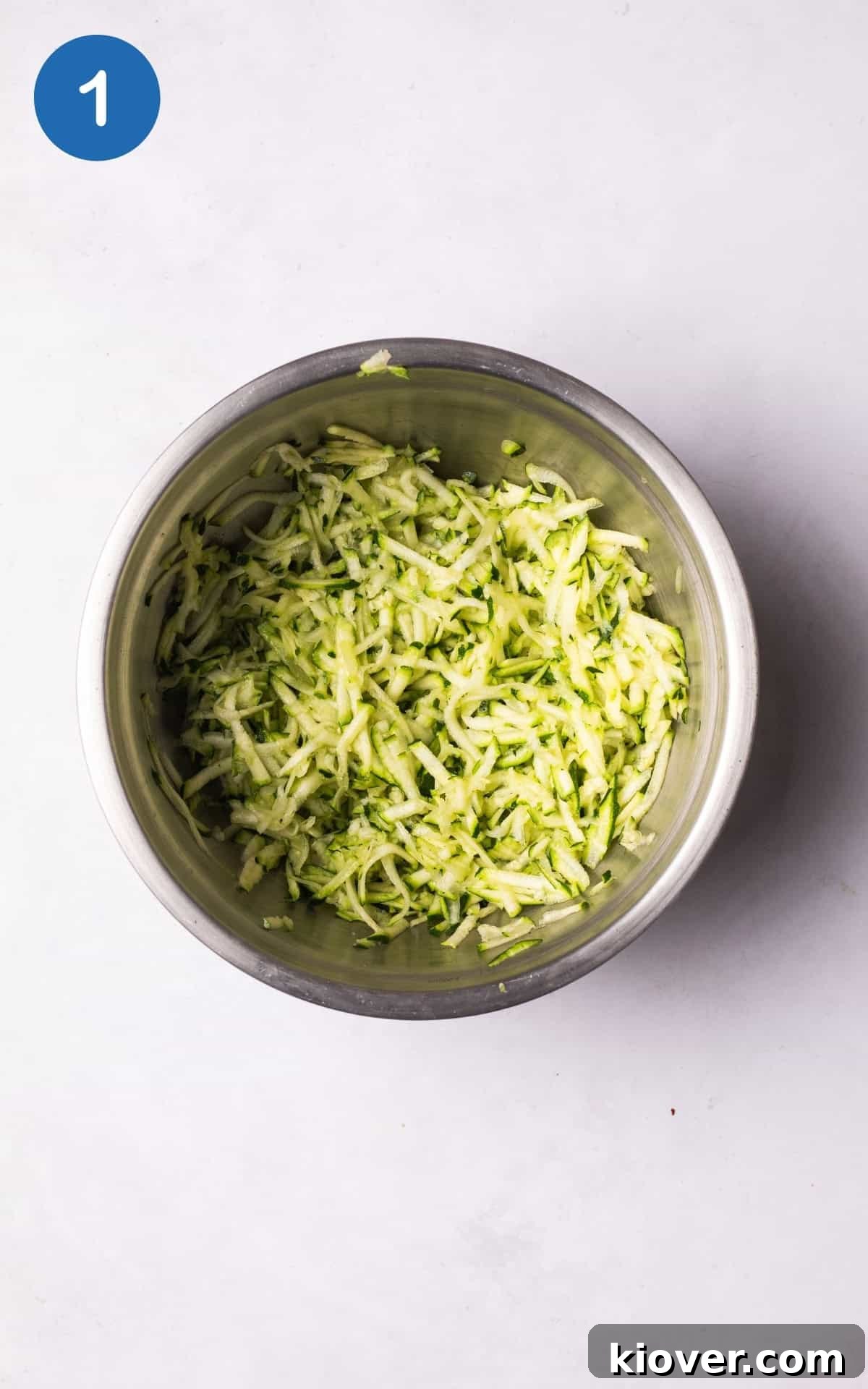 Crispy Zucchini Fritters 4 Grated courgette in a bowl, salted to draw out excess liquid.