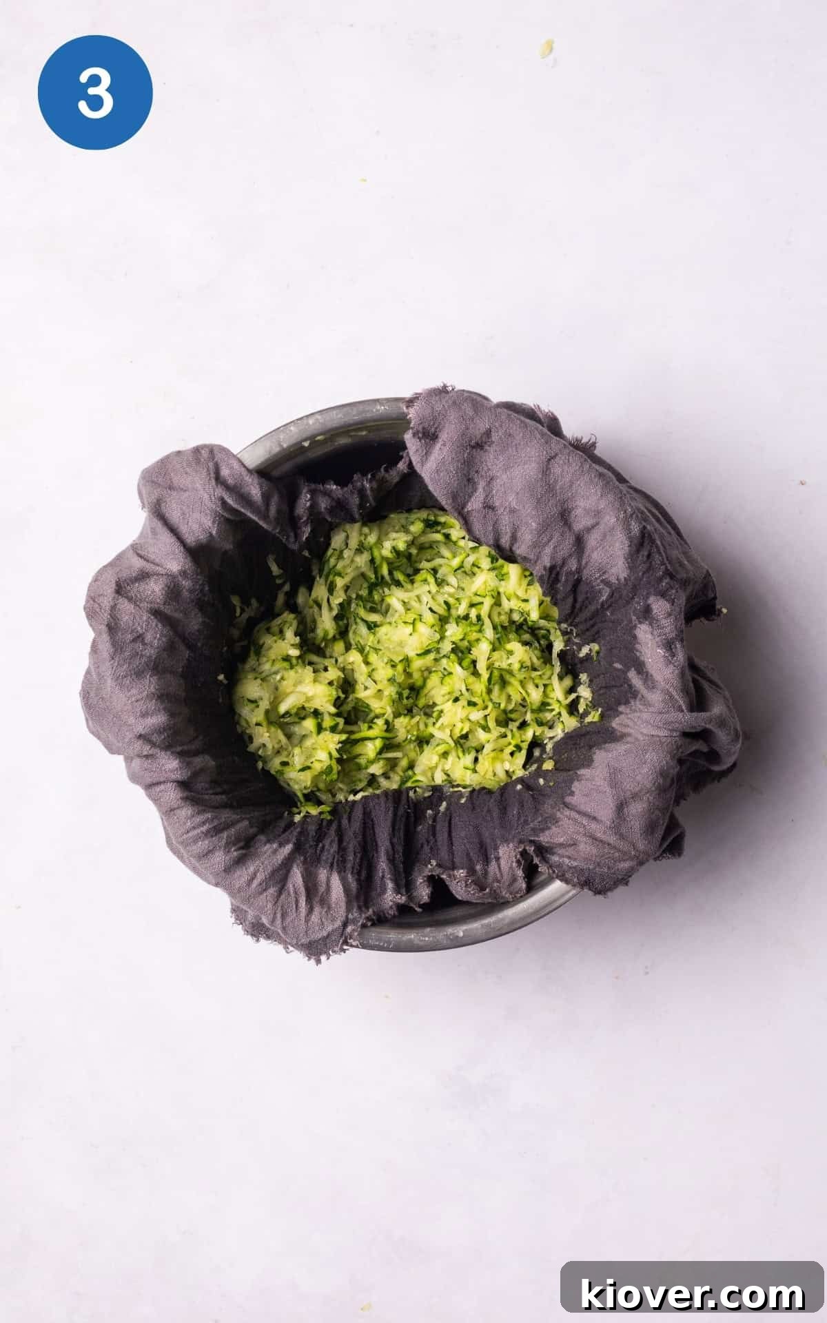 Crispy Zucchini Fritters 6 Using a tea towel to squeeze out excess water from grated courgette.