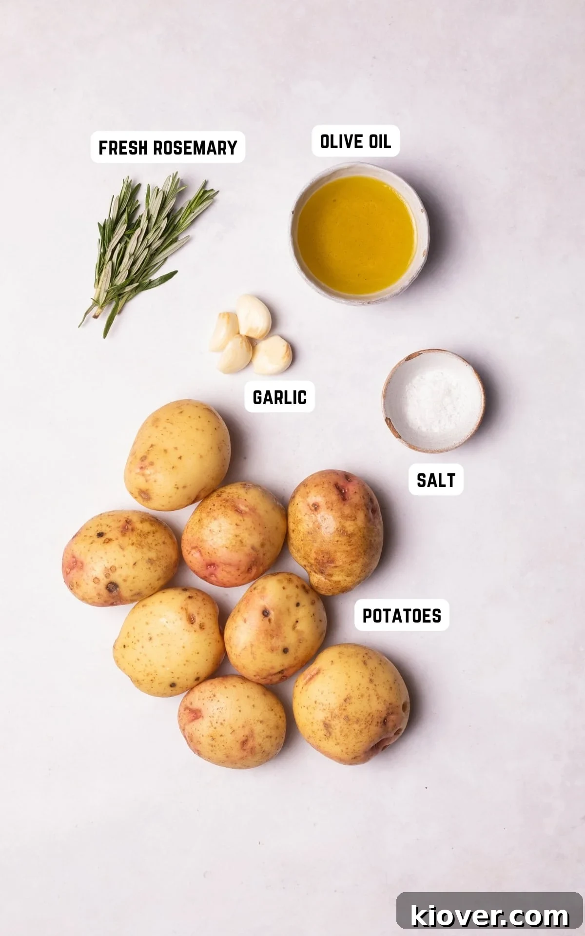 Golden Roasted Potato Cubes 3 Ingredients for Parmentier Potatoes: diced potatoes, olive oil, garlic cloves, fresh rosemary, and salt laid out.