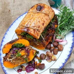 A beautifully roasted stuffed butternut squash on a white plate, sliced open to reveal the hearty filling.