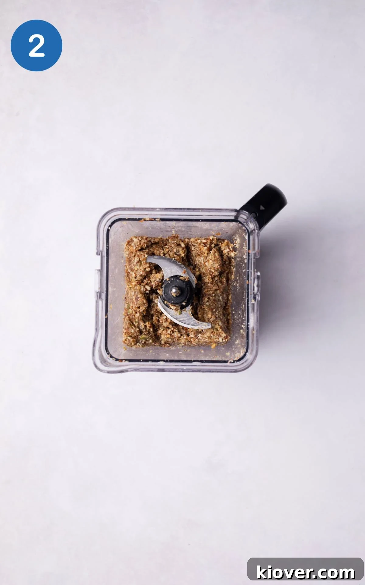 Chestnuts, pecans, and dried apricots being mixed together in a food processor to form crumbs.