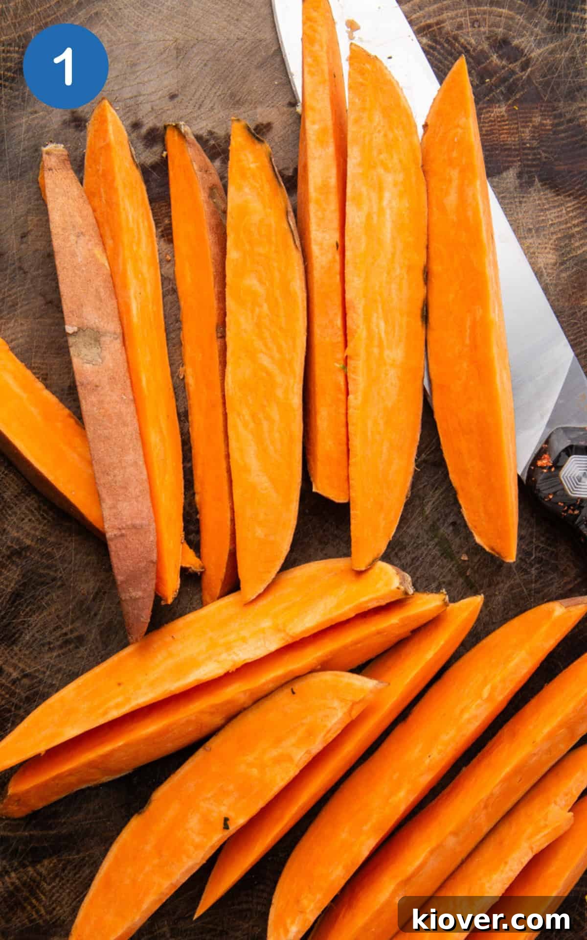 Crispy Air Fryer Sweet Potato Fries 4 Sweet potato being precisely sliced with a sharp knife into evenly sized wedges on a cutting board.