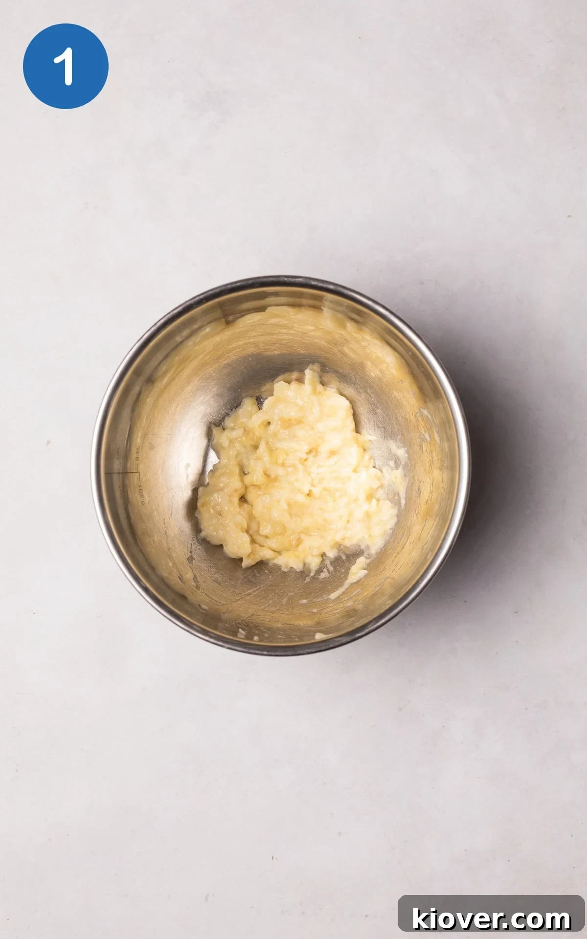 A mashed banana in a bowl, ready for the next ingredients to be added.
