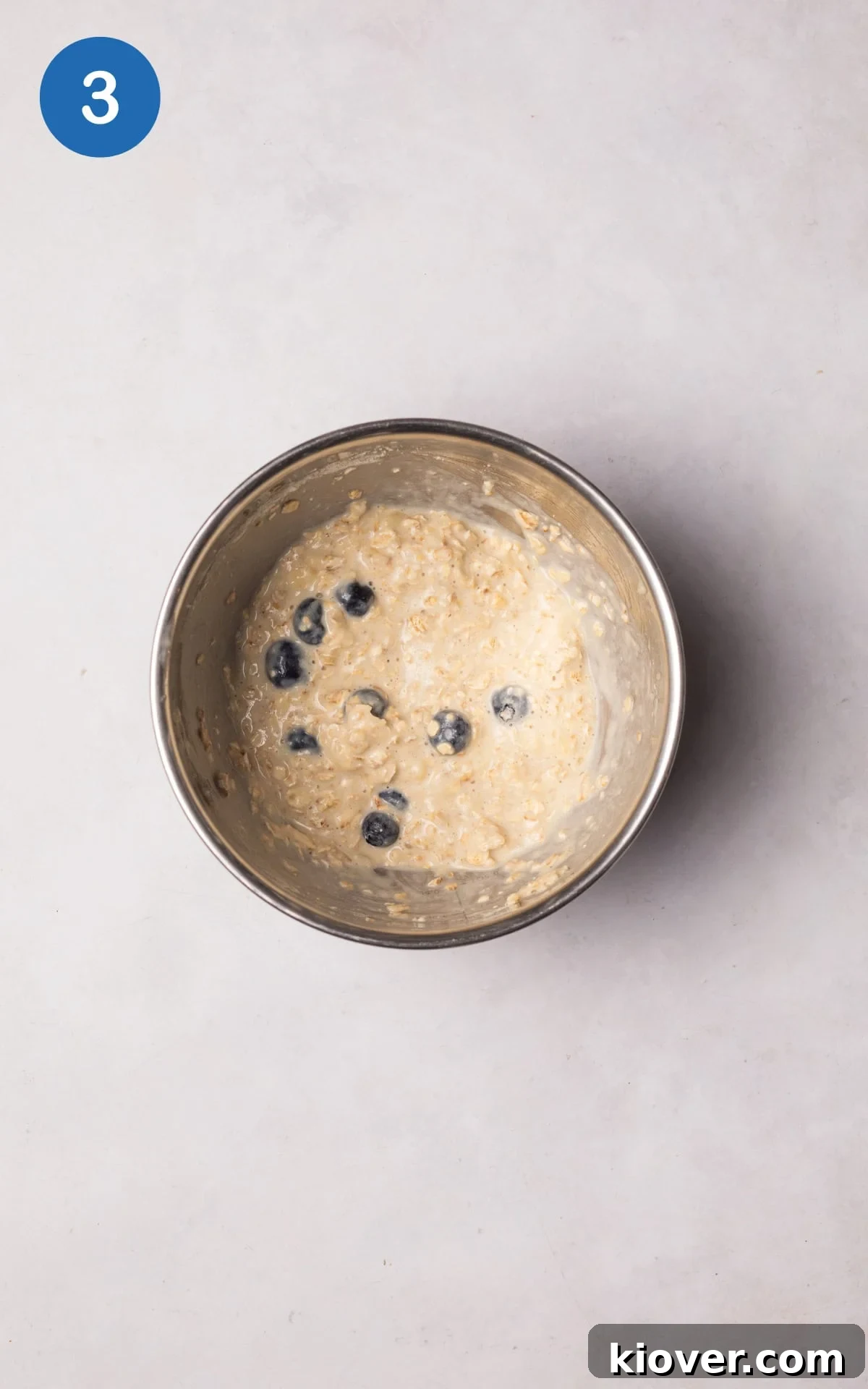 Blueberries folded into the oat mixture in a bowl.