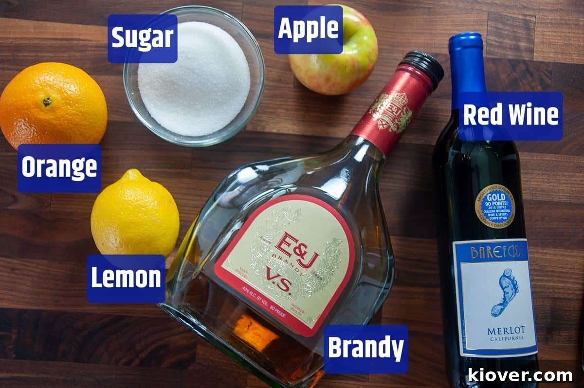 Red Sangria Ingredients Sugar, apple, red wine, brandy, lemon, and orange on a cutting board, ready for Sangria.