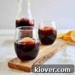 Side view of two sangrias with a carafe of the same in the background