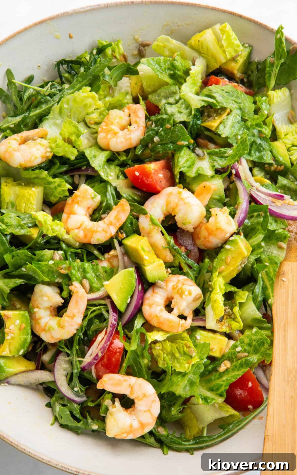 Vibrant Prawn Bowl 8 Shrimp avocado salad generously drizzled with maple dijon dressing, served in a wide bowl.