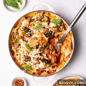 Hearty Sausage & Pasta Casserole 10 A hearty sausage pasta bake with vibrant vegetables, topped with melted cheese, served in a rustic baking dish.