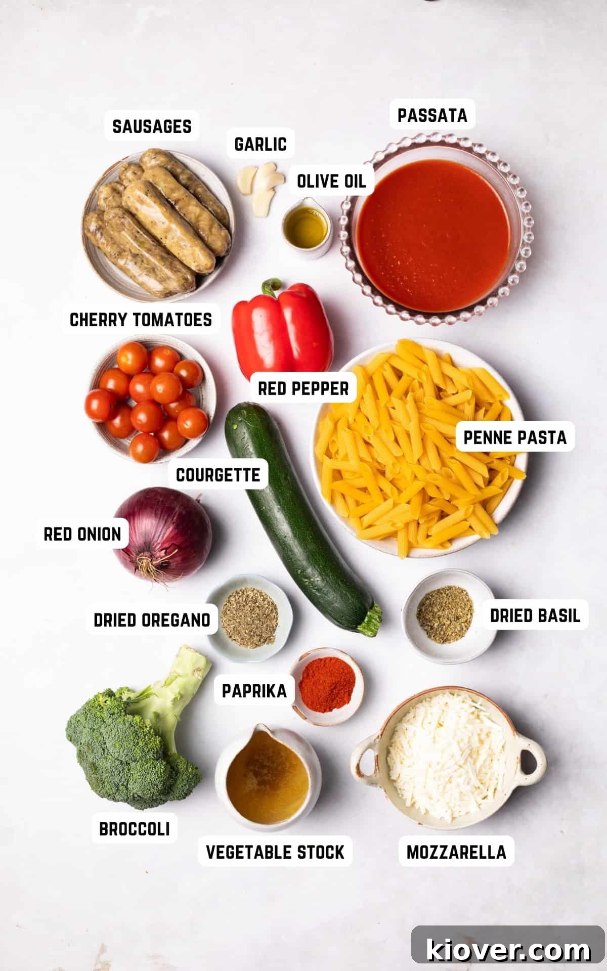 Hearty Sausage & Pasta Casserole 3 Fresh, colorful ingredients for Sausage Pasta Bake laid out on a wooden surface.