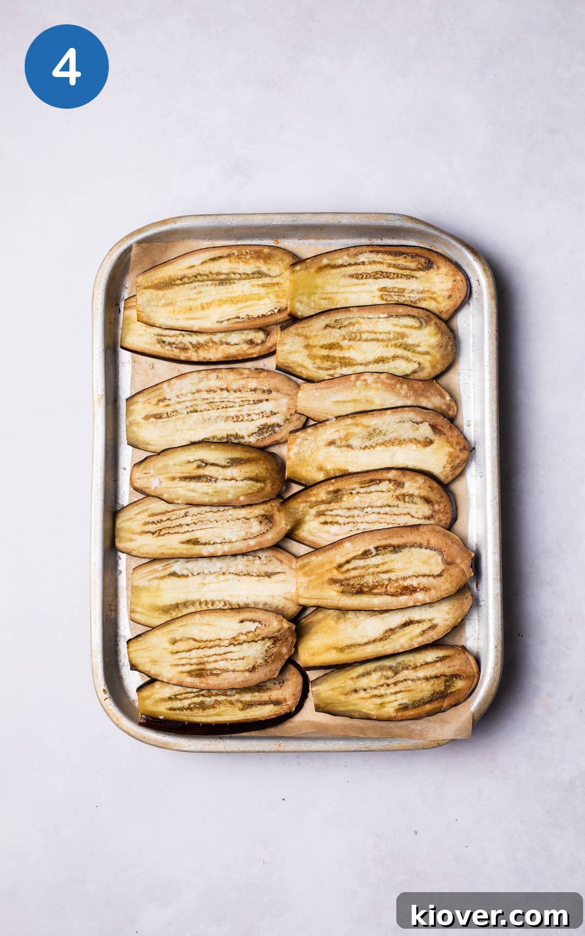 Plant-Based Moussaka Perfection 7 Thin strips of aubergine laid out on a baking tray, lightly drizzled with olive oil, ready for roasting to achieve tenderness.