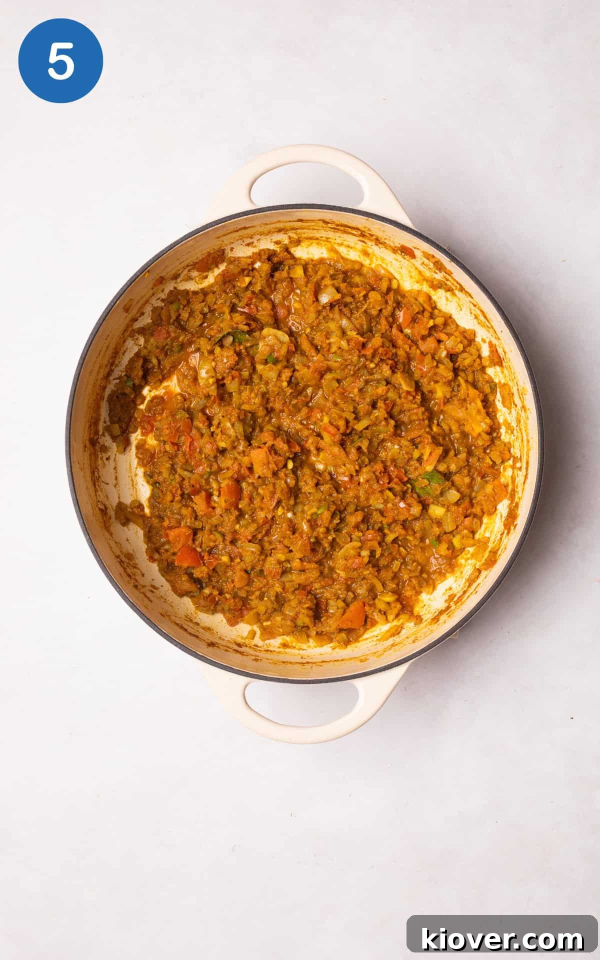 Adding the blended tomato mixture to the pan.