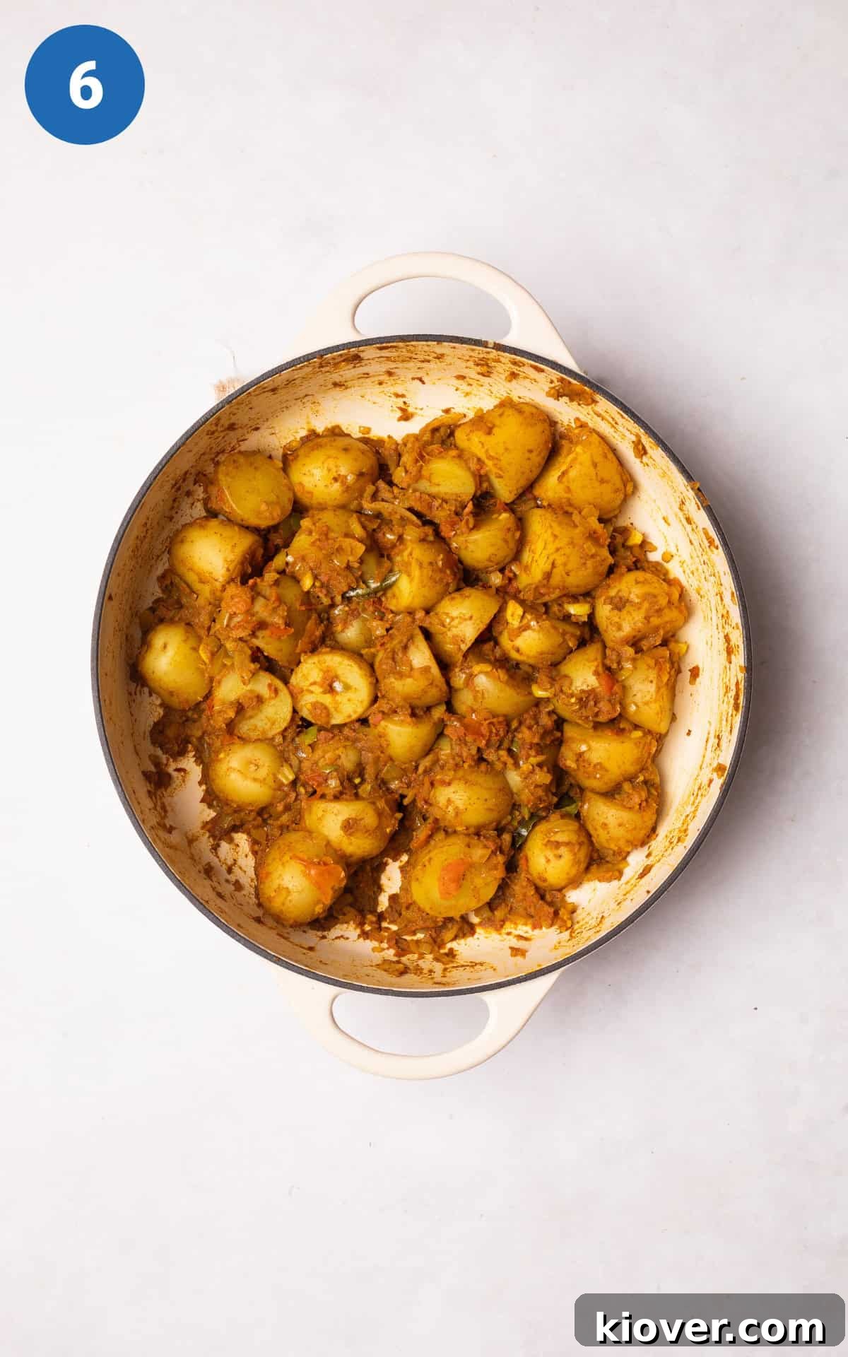 Adding the drained potatoes to the pan.