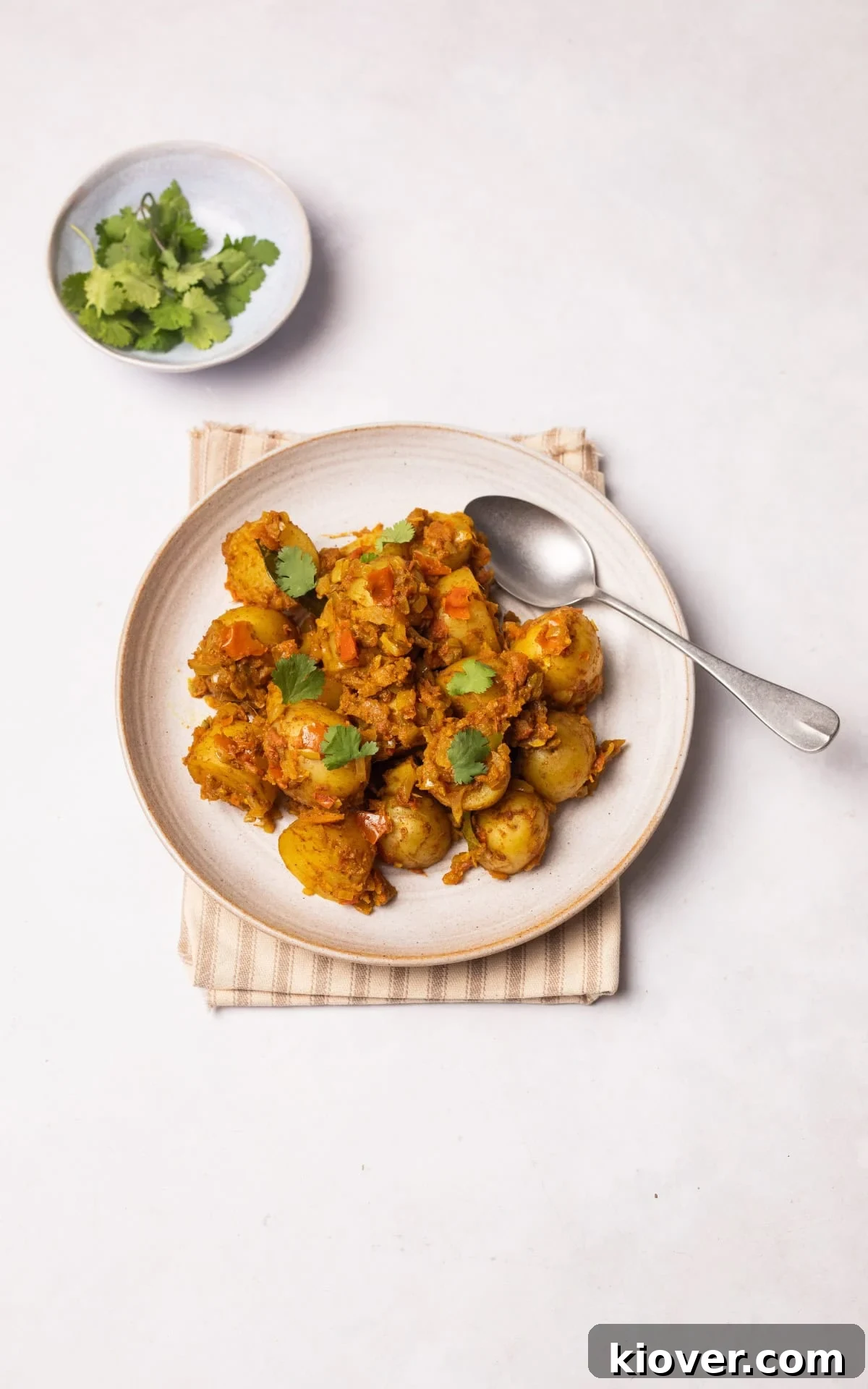 Bombay Aloo (Bombay Potatoes) served on a plate with fresh coriander.