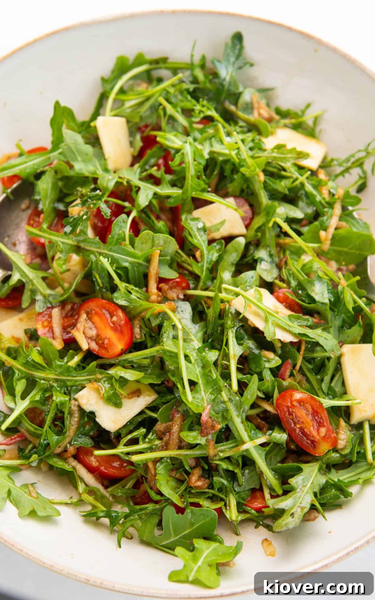 A vibrant arugula salad with cherry tomatoes, shaved parmesan, and a glistening balsamic dressing.