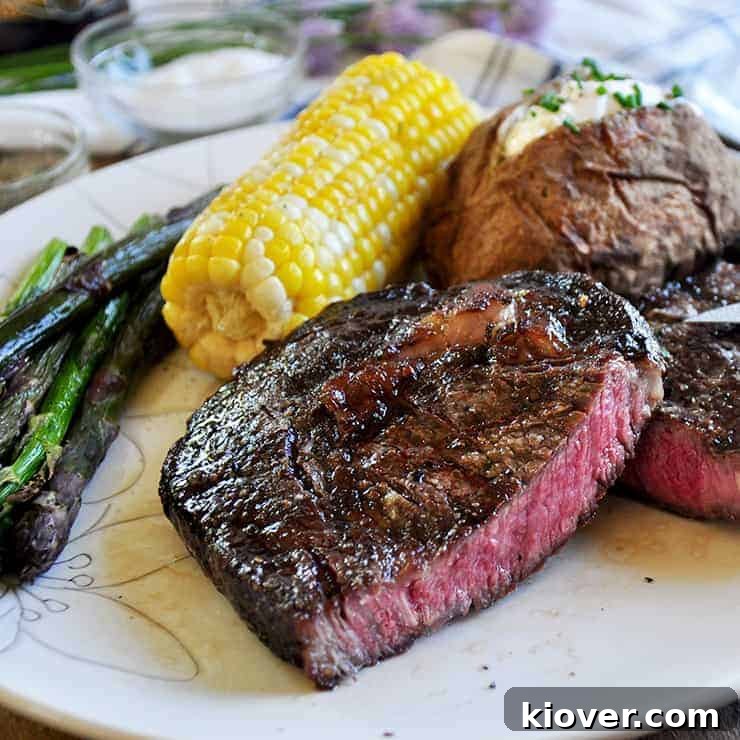 A perfectly cooked ribeye steak, sliced to reveal a juicy, medium-rare center, resting on a wooden cutting board, ready to be served.