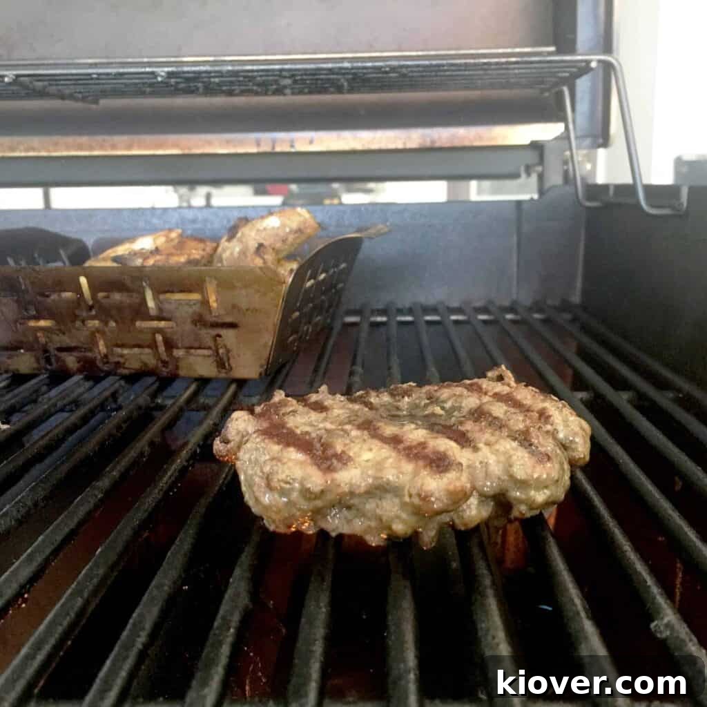 A perfectly formed sirloin burger patty with a thumbprint divot, ready for grilling to prevent swelling and ensure even cooking.
