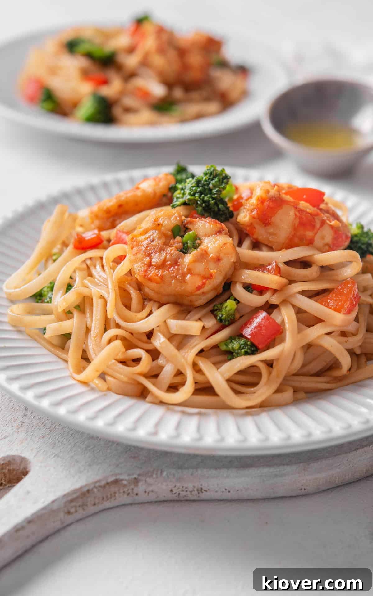 Savory Prawn Noodles 8 noodles with shrimp and vegetables served on a white plate.