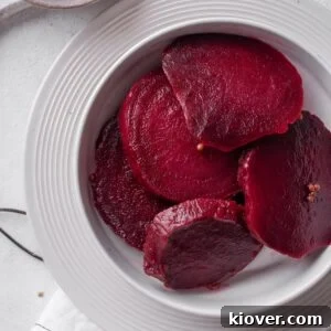 Pickled beetroot served on a white plate, showcasing its vibrant color and inviting texture.