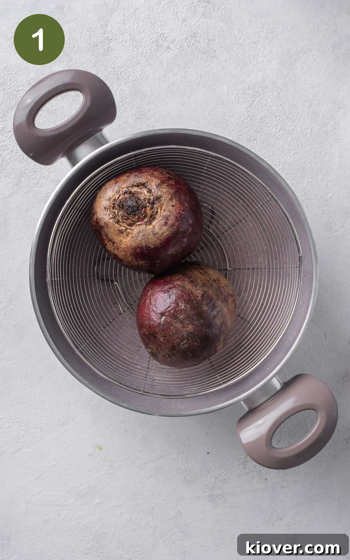 Freshly scrubbed beets placed in a steaming basket, ready for cooking.