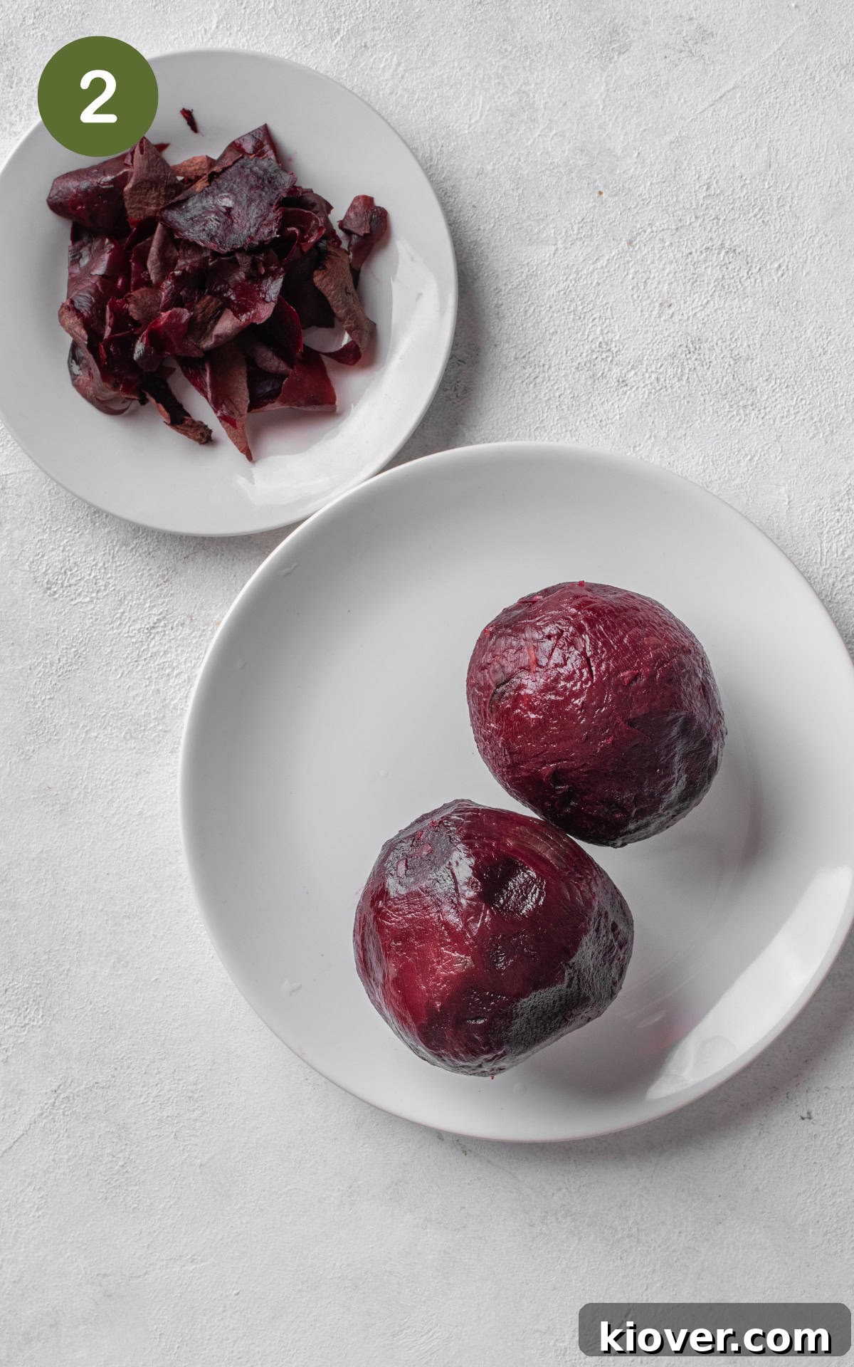 Cooked beets with their skin easily peeling off, indicating they are ready for slicing.