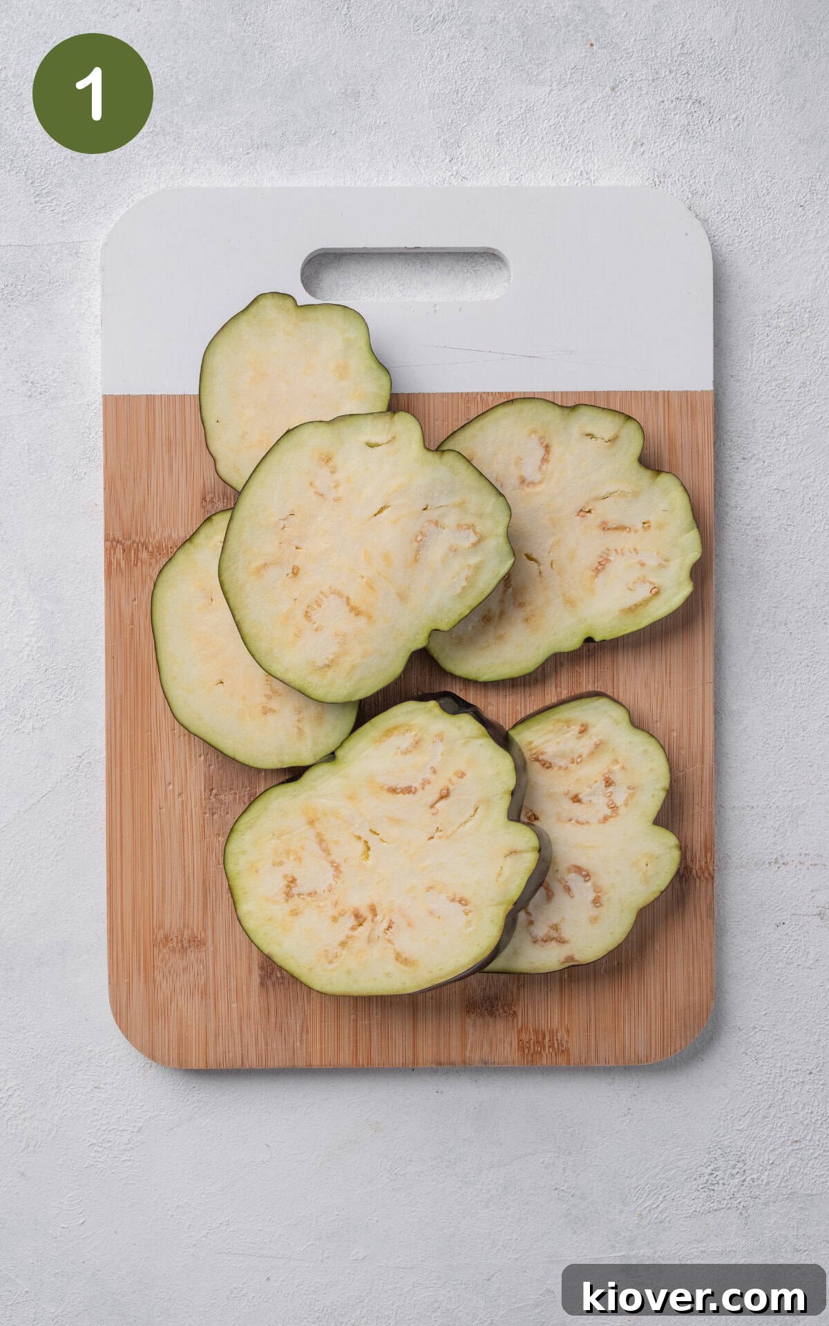 Italian Eggplant Comfort Bake 4 aubergine slices on a wooden cutting board.