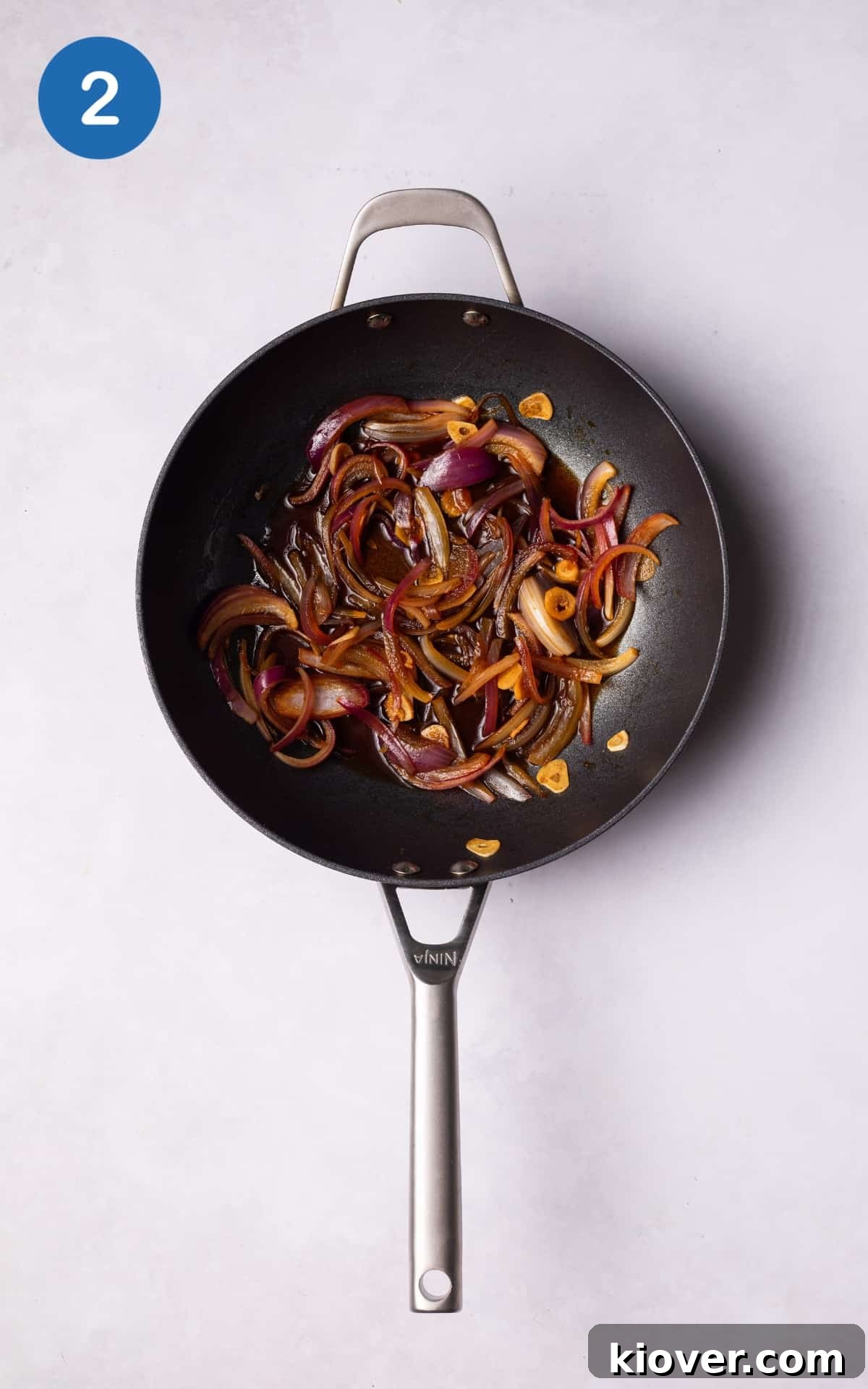 Red onion, garlic, and ginger sizzling in a hot wok with tamari, lime juice, and maple syrup.