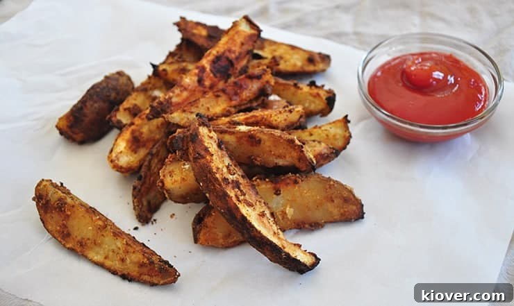Done Potato Wedges finished servings of potatoes on some paper and served with a small glass bowl of ketchup