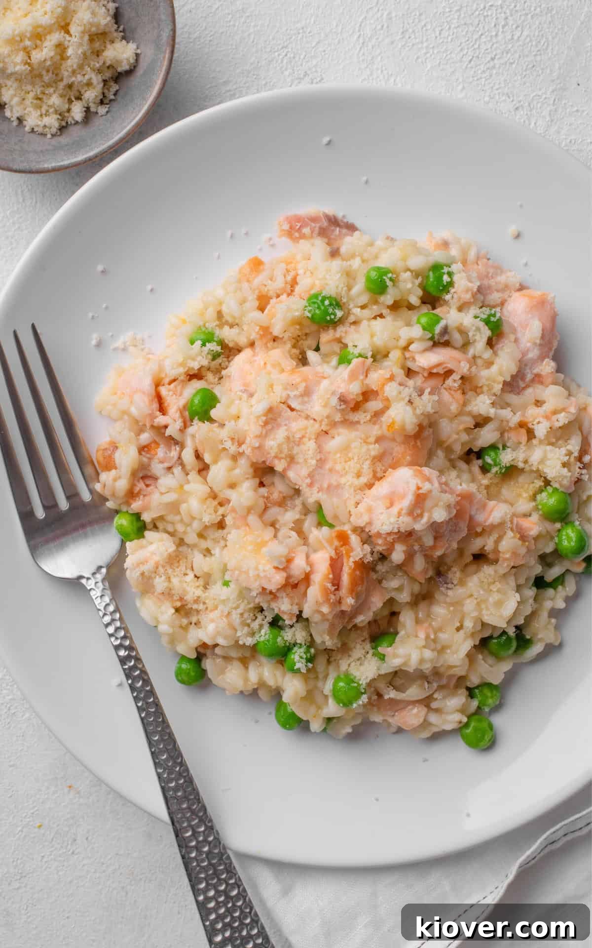 A close-up of a serving of creamy salmon risotto, garnished with fresh dill.