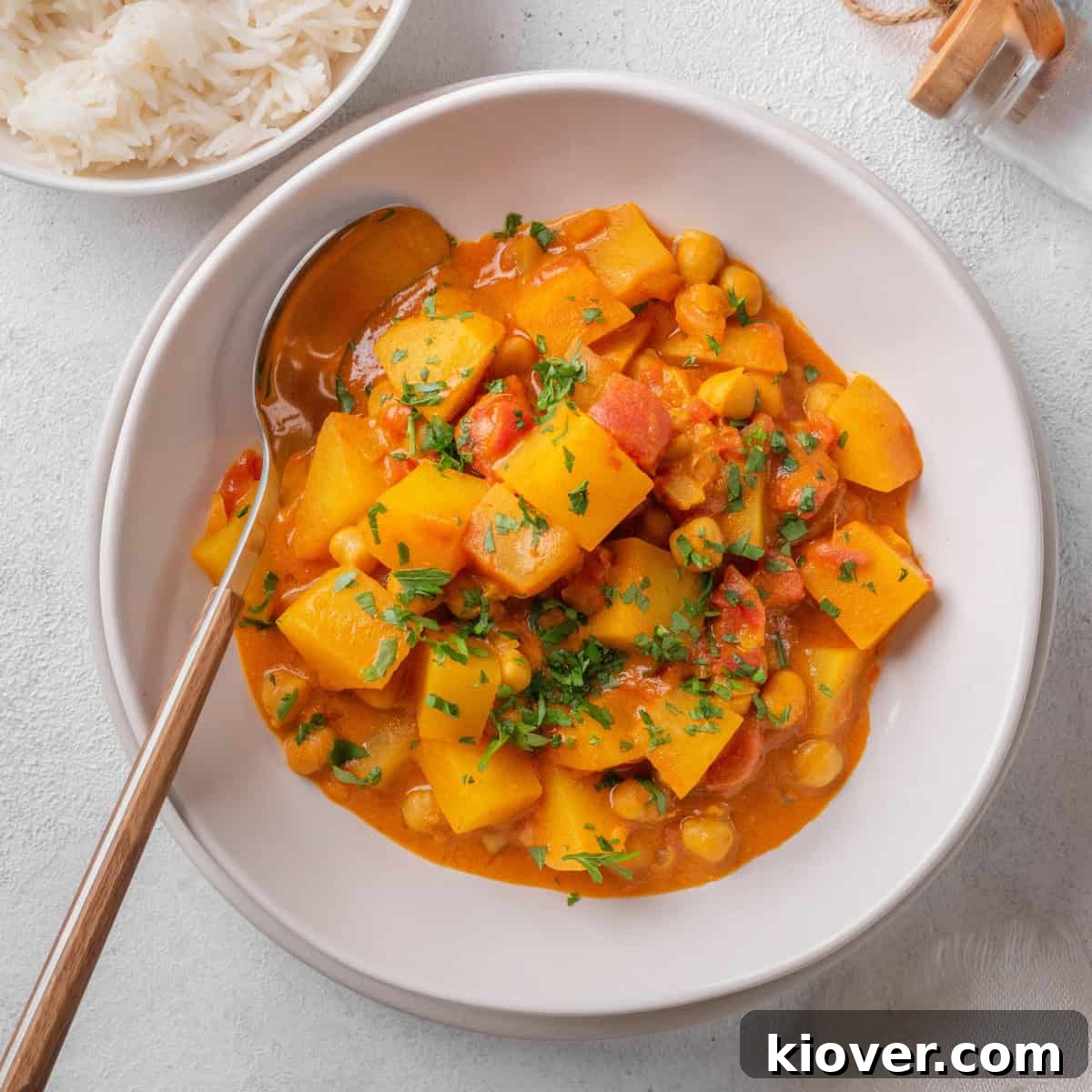 Golden Potato Curry 2 Delicious Potato Curry (Aloo Curry) served on a plate, garnished with fresh herbs.