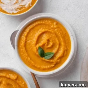 A cozy bowl of creamy roasted carrot and parsnip soup, garnished and ready to be served.