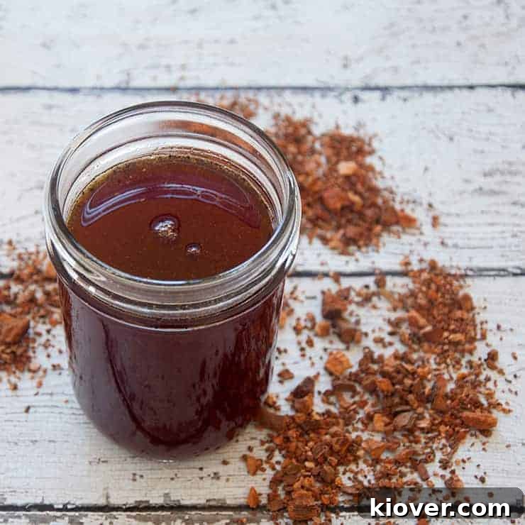 A pint of tonic syrup for homemade tonic water, showcasing its rich, amber hue