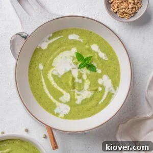 A bowl of creamy broccoli soup garnished with fresh herbs, ready to be served.
