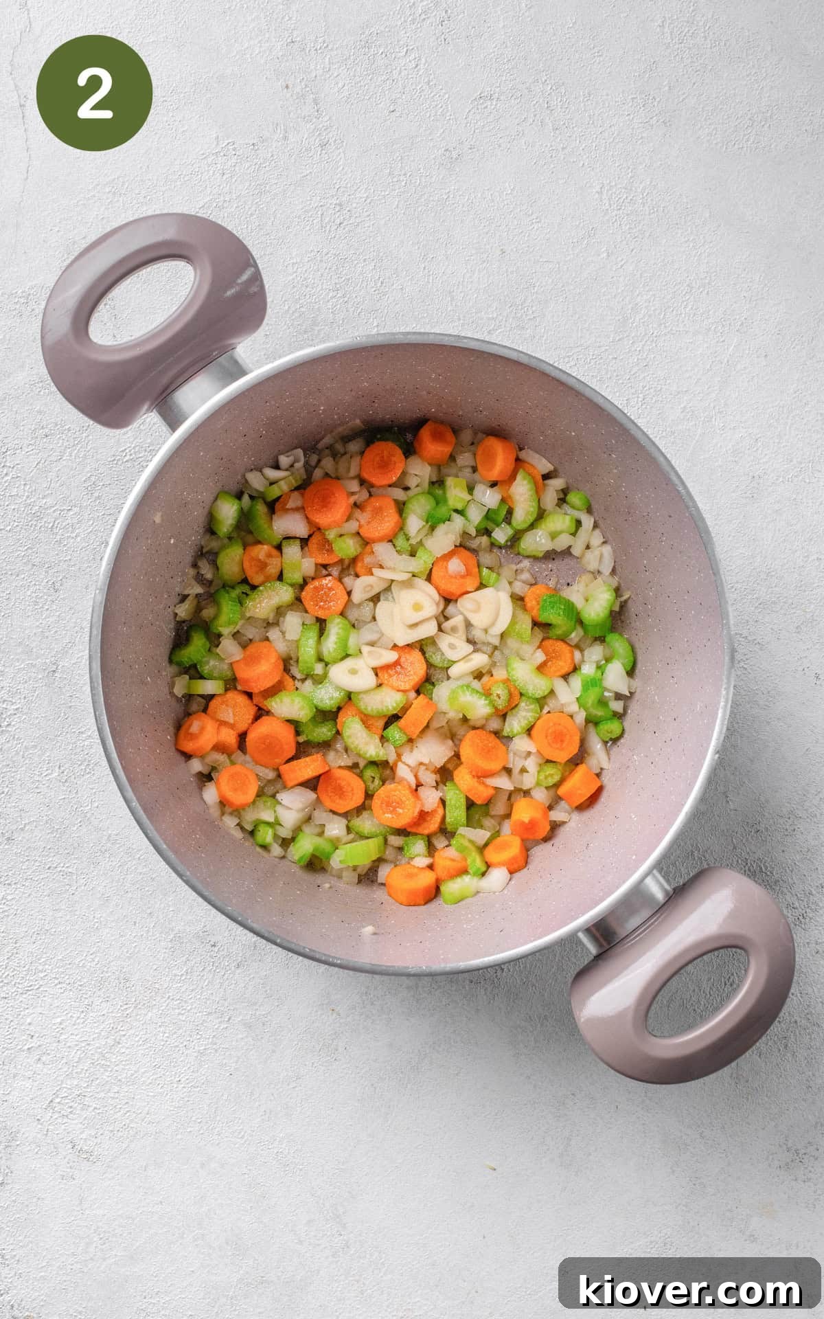 Diced onions, sliced carrots, and chopped celery sautéing in olive oil in a large pot over medium heat.