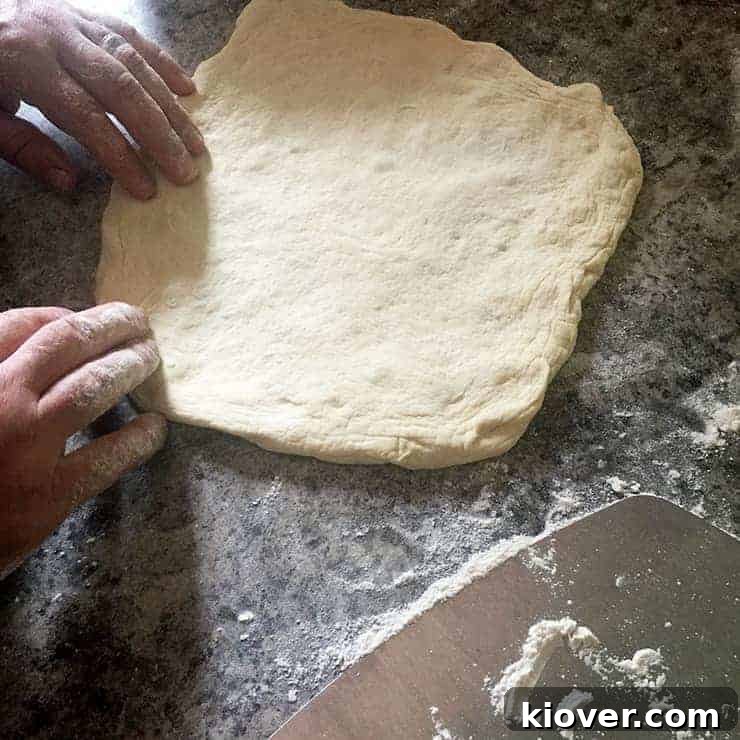 Stretching Dough Pizza Dough mid stretch, showcasing the gentle technique.