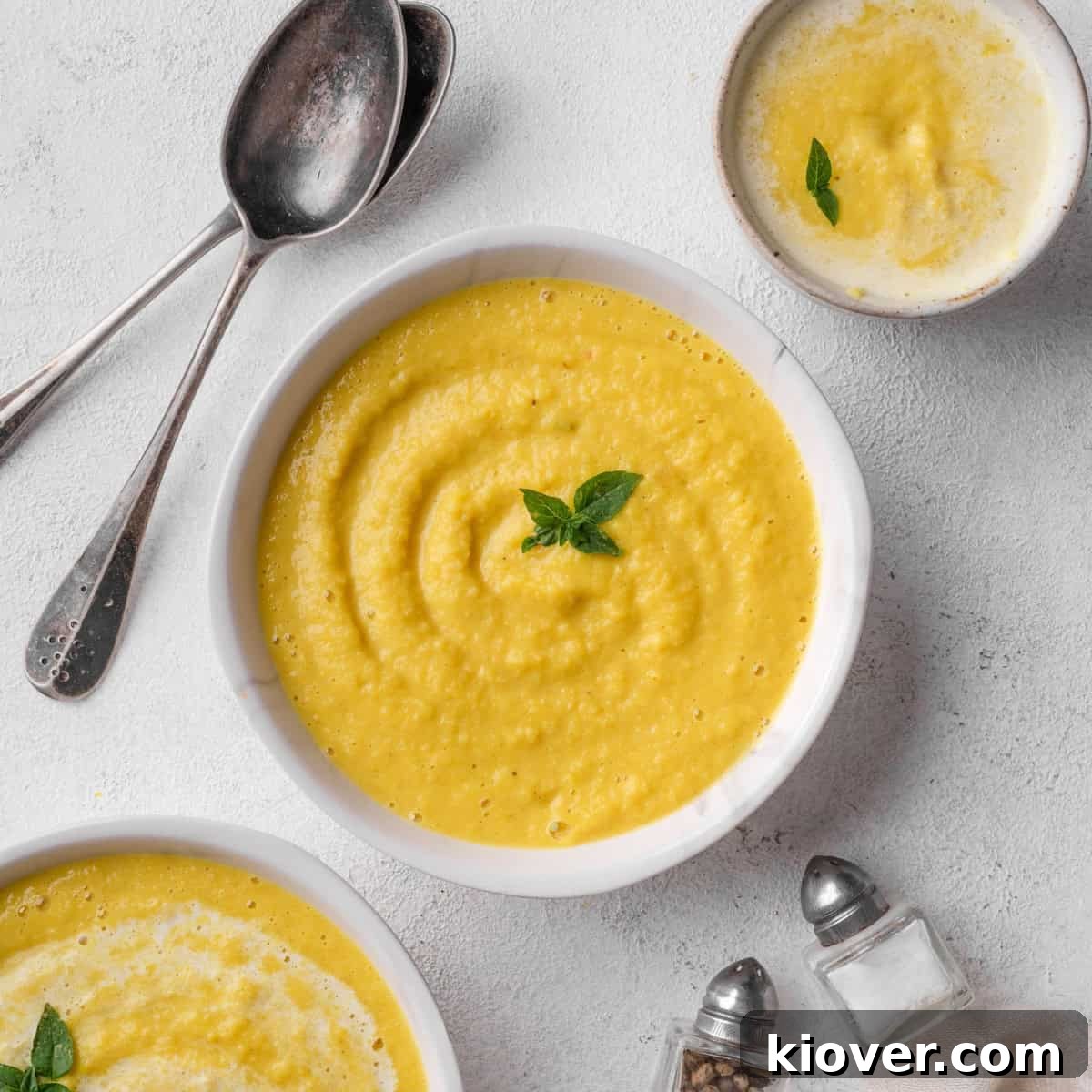 Curried parsnip soup served in a rustic bowl, garnished with fresh herbs.