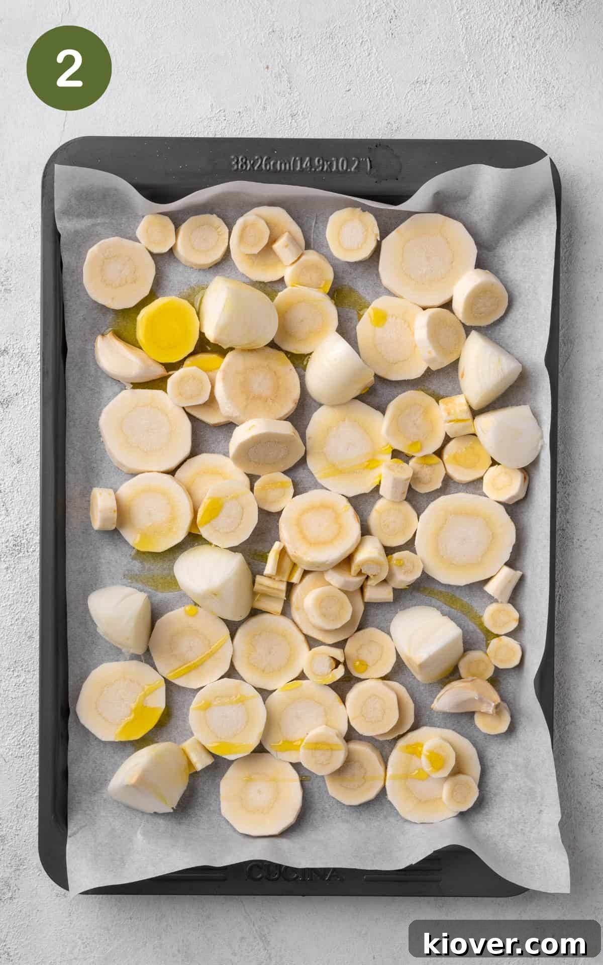 Prepared vegetables, drizzled with olive oil and seasoned, arranged on a baking sheet.