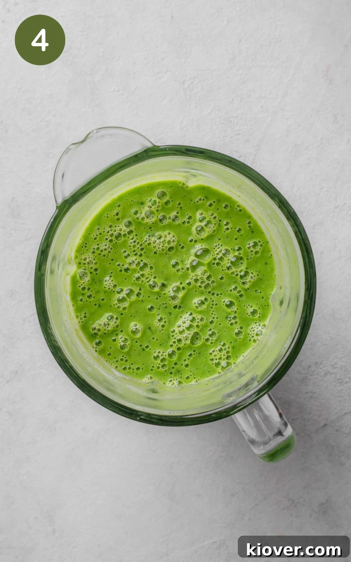 Silky Minted Pea Soup 7 The vibrant green pea and mint soup mixture being pureed in a food blender until smooth.
